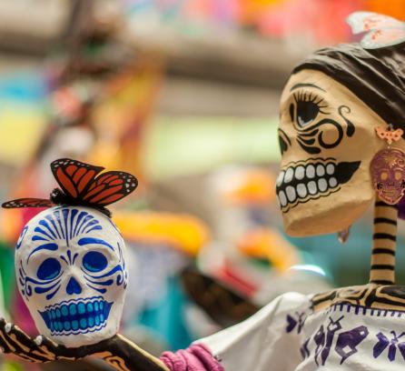 Day of the dead skeleton holding calavera, or sugar skull.