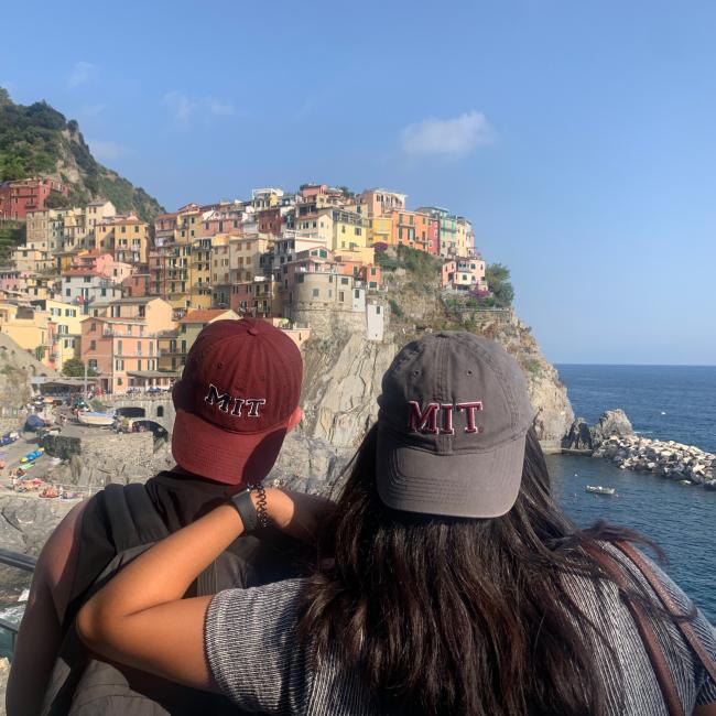 Students with MIT hats looking toward mountain with buildings