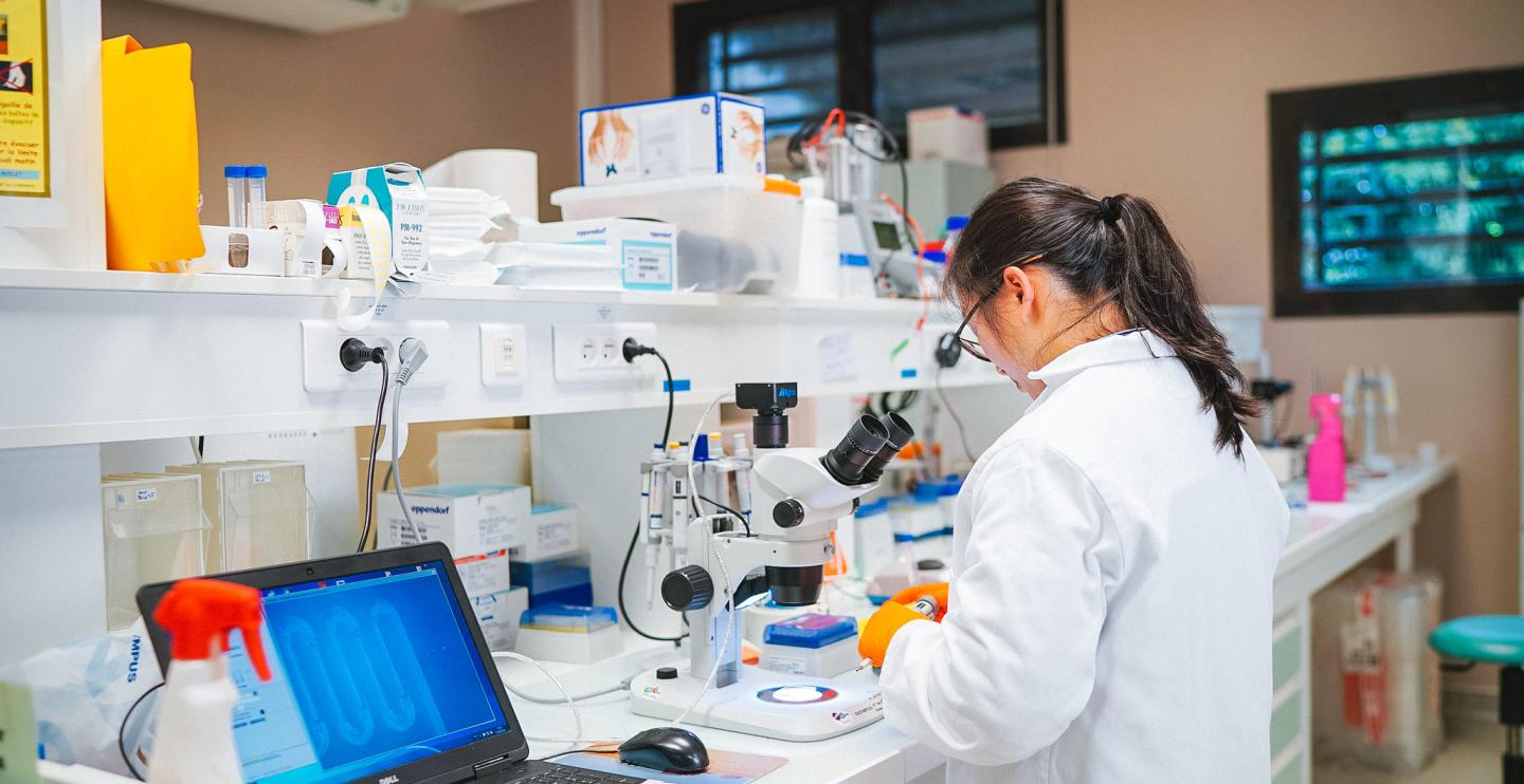 student looking through microscope in lab in France