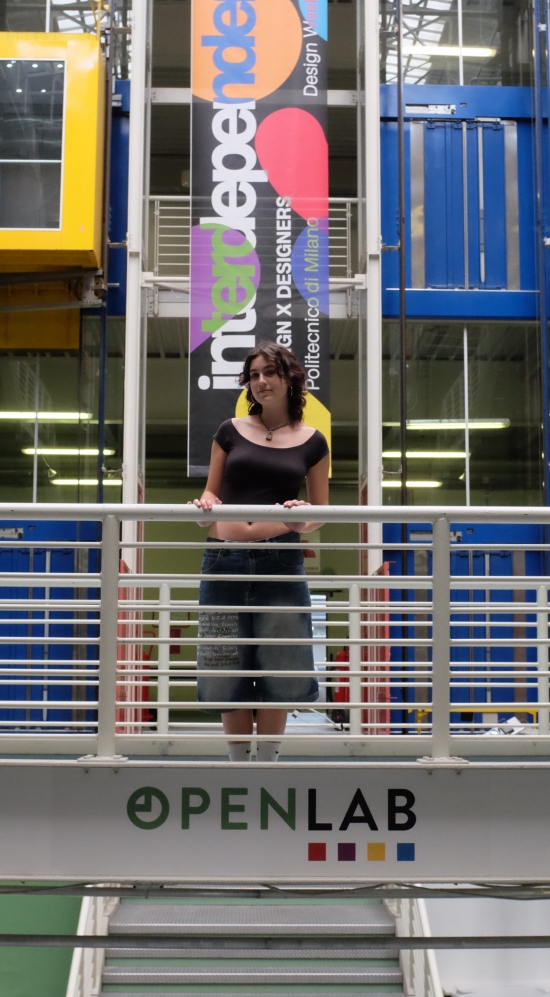 Layla Stator leaning on a white railing on the second floor in Politecnico di Milano