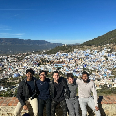 5 students in front of city backdrop