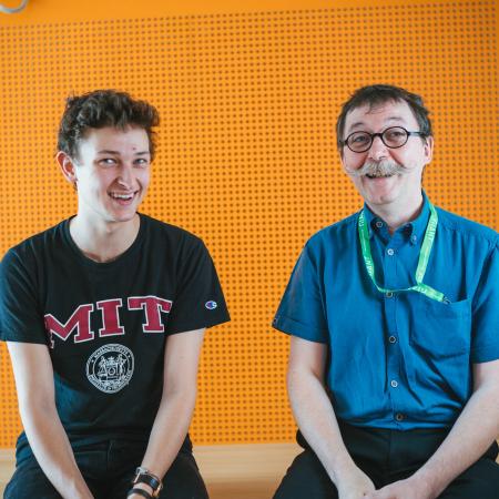 Student and host smiling in office