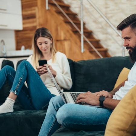 people on their phone and laptop in a living room